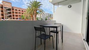 d'une table et de chaises sur un balcon avec un palmier dans l'établissement Nice Industrial Studio Teror 206, à Playa del Ingles