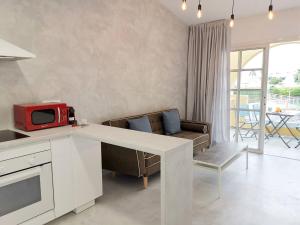 kuchnia z białym blatem i salon w obiekcie Apartament Tisalaya 44 By Pride Holiday Rentals w mieście Maspalomas