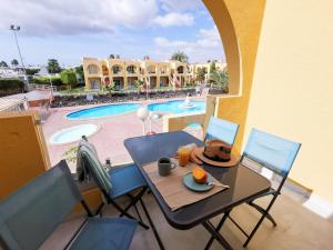 stół i krzesła z talerzem jedzenia w obiekcie Apartament Tisalaya 44 By Pride Holiday Rentals w mieście Maspalomas