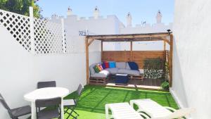 patio z łóżkiem, stołem i krzesłami w obiekcie Marbella Golf 101 By Pride Holiday Rentals w mieście Maspalomas