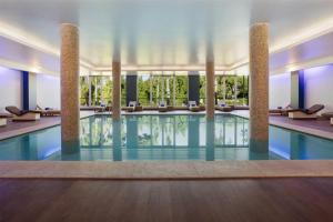 a swimming pool in a hotel with columns at Wyndham Grand Algarve in Quinta do Lago