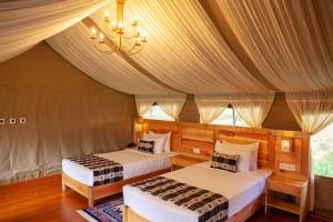 une chambre avec deux lits dans une tente dans l'établissement Gangtey Tent Resort, à Gangtey Gonpa