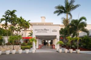 モンテゴ・ベイにあるGrand Decameron Montego Beach, A Trademark All-Inclusive Resortの前にヤシの木がある建物