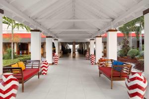 モンテゴ・ベイにあるGrand Decameron Montego Beach, A Trademark All-Inclusive Resortの赤と白の縞模様のベンチが置かれた屋根付きのポーチ