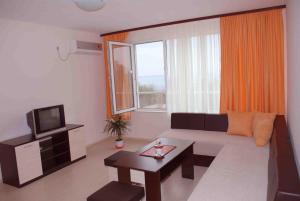 a living room with a couch and a tv at Hotel Topalovi in Nesebar