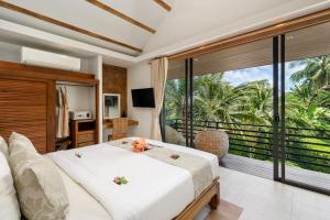 a bedroom with a bed and a large window at Khwan Beach Resort - Luxury Glamping and Pool Villas Samui - Adults Only - SHA Extra Plus in Mae Nam