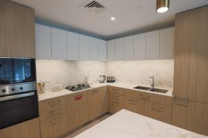 a kitchen with wooden cabinets and a stove top oven at Stylish Studio at Berkeley Place by Ellington in Dubai