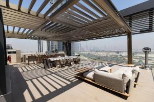 a balcony with a couch and tables on a building at Stylish Studio at Berkeley Place by Ellington in Dubai