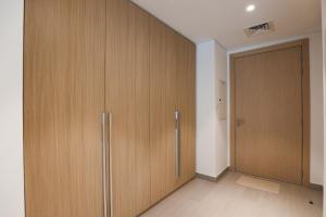 a room with wooden cabinets and a door at Stylish Studio at Berkeley Place by Ellington in Dubai
