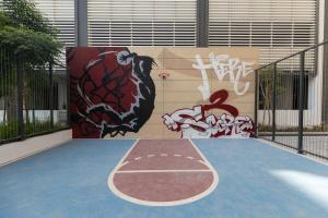 a basketball court with graffiti on the side of a building at Stylish Studio at Berkeley Place by Ellington in Dubai