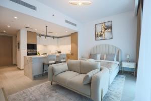 a living room with a bed and a kitchen at Stylish Studio at Berkeley Place by Ellington in Dubai