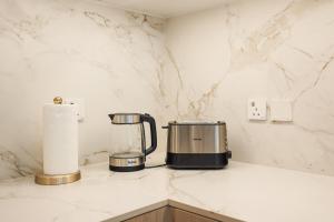 a kitchen counter with a coffee maker and paper towels at Stylish Studio at Berkeley Place by Ellington in Dubai