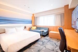 a hotel room with a bed and a desk at Richmond Hotel Miyazakiekimae in Miyazaki