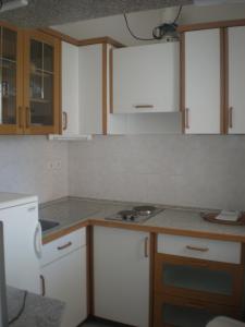 een keuken met witte kasten en een aanrechtblad bij Apartments Fuchs in Umag