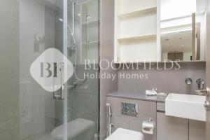 a bathroom with a shower and a toilet and a sink at Bloomfields 1BR Elegant in Shams Meera in Abu Dhabi +8 photos