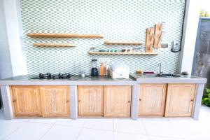 a kitchen with wooden cabinets and a counter top at Sandat Bali Villa Canggu in Canggu