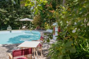 a table and chairs next to a swimming pool at Casa das Figuras in Sintra