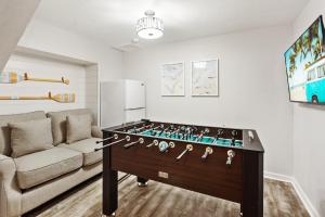 a living room with a foosball table in front of a couch at 7041 - Toes in the Sand in Whalebone