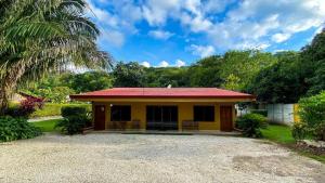 a small yellow house with a red roof at Cabinas Liz in Veintisiete de Abril
