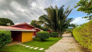 a house with a palm tree next to a driveway at Cabinas Liz in Veintisiete de Abril