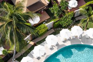 an overhead view of a pool with chairs and umbrellas at Khwan Beach Resort - Luxury Glamping and Pool Villas Samui - Adults Only - SHA Extra Plus in Mae Nam