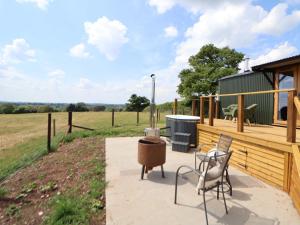 a patio with a grill and two chairs on a deck at The Coop in Market Drayton