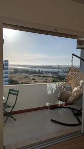 a balcony with a rattan chair and a swing at Penthouse Studio Sea View in Alvor