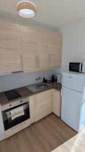 a kitchen with wooden cabinets and a white refrigerator at Penthouse Studio Sea View in Alvor