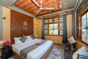 a bedroom with a bed and a ceiling fan at Sony Place Villa and Resort in Kasol
