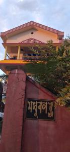 un bâtiment avec une enseigne sur le côté dans l'établissement Maadhuban Home Stay, à Dibrugarh
