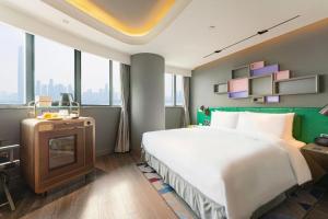a hotel room with a large bed and a television at Ethos Hotel Wuhan Riverside in Wuhan +272 photos