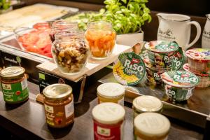 a table topped with jars of food and vegetables at Motel One Prague-Florentinum in Prague