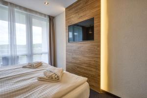 a bedroom with a bed and a tv on a wall at Hotel Szieszta in Sopron