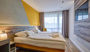 a bedroom with a bed and a large window at Hotel Szieszta in Sopron +66 photos