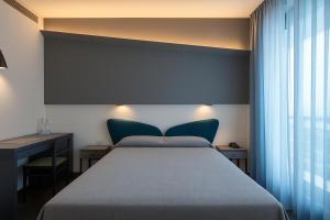 A bed or beds in a room at Hotel Ali d'Oro