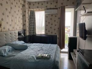 a bedroom with a bed with two remote controls on it at Vins Room at Vivo Apartemen in Seturan +4 photos