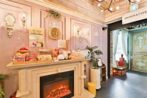 a living room with a fireplace and a clock on the wall at Daegu February Hotel Suseong in Daegu
