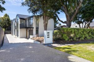 a house with a white door on a street at Modern living at its finest in Dunedin
