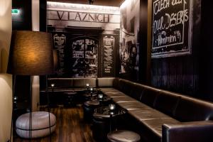 a bar with a leather bench and stools at Motel One Prague-Florentinum in Prague