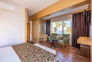 Una habitación de hotel con una cama, un sofá y un escritorio. en Fame Beach Hotel, en Kemer 53 fotos más