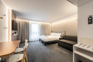 ランスにあるHoliday Inn Express & Suites Reims - Rives de Vesle by IHGのベッドとソファとテーブルがあるホテルの部屋 +68枚の写真