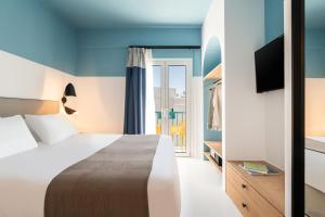 a hotel room with a bed and a tv at Play Paros in Kampos Paros