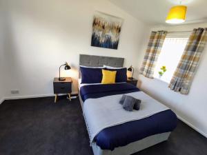 a bedroom with a large bed with blue and yellow pillows at Sigma Haven, Free Parking in Old Walker