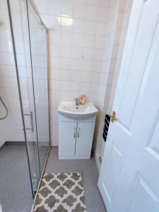 a white bathroom with a sink and a shower at Sigma Haven, Free Parking in Old Walker