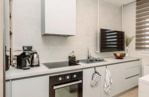 a kitchen with a sink and a stove top oven at 8 Blocks Apartments - Alexandroupoli in Alexandroupoli