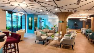 a waiting room with couches and chairs at Emerald Garden International Hotel in Medan