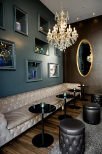 a living room with a couch and two tables and a chandelier at Motel One Prague-Florentinum in Prague