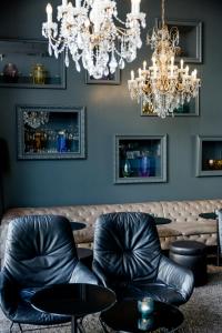 a bar with black leather chairs and a chandelier at Motel One Prague-Florentinum in Prague