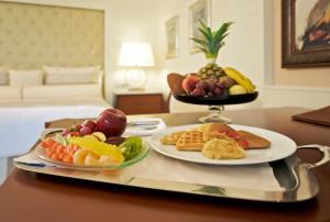 a tray with two plates of fruit on a table at Iberostar Grand Bavaro Hotel in Punta Cana