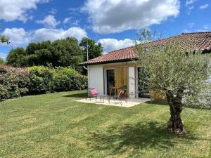 a small white house with a tree in the yard at Studio neuf avec Terasse Jardin in Seignosse